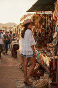 Native American model wearing white lace tiered top at outdoor market